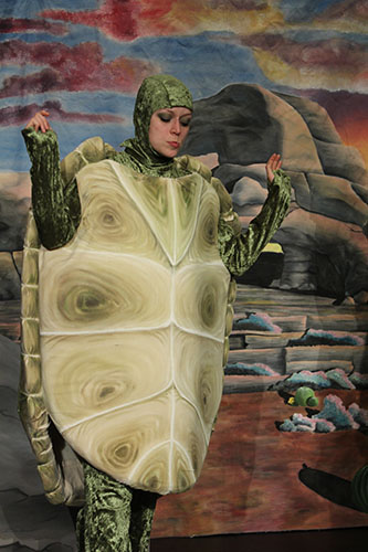 EIne Schildkröte im Kindertheater Die Schildkröte und der Wunschfelsen durch die Schauspielerin Maja Makowski verkörpert.